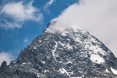 Low angle view of snowcapped mountain against sky