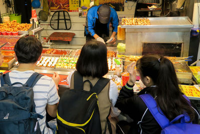 Rear view of people sitting at market