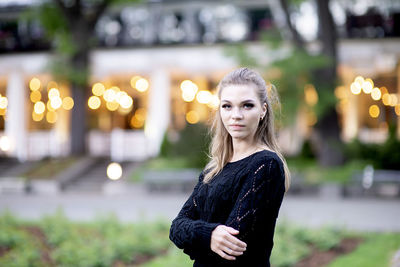 Portrait of a cute and gorgeous young woman on blurred street background with bokeh light