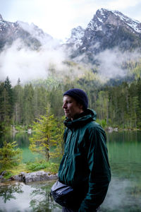 Man looking at waterfall in forest