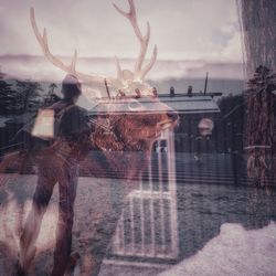 Digital composite image of deer with lake in background