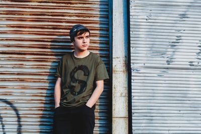 Portrait of a boy standing against wall