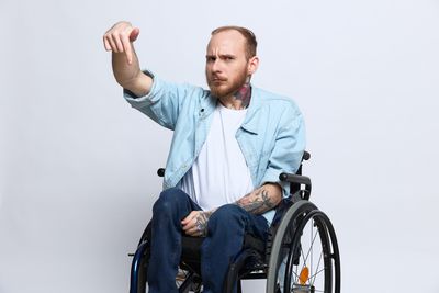 Portrait of young man standing against white background