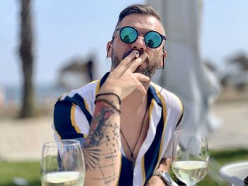 Portrait of young man wearing sunglasses while standing outdoors
