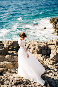 Woman standing on rock at beach