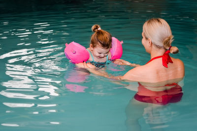 Girl and woman in swimming pool