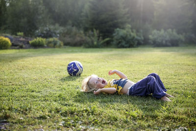 Happy boy lying on lawn