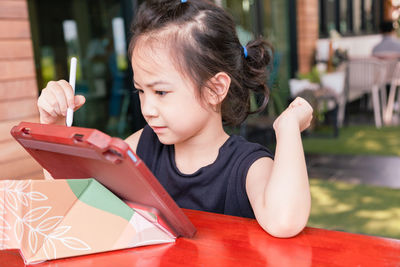 Girl using digital tablet while studying