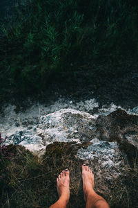 Low section of woman standing on cliff