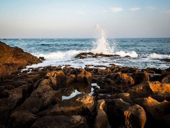 Scenic view of rocks in sea against sky