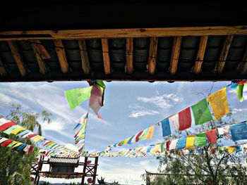 Low angle view of flags hanging against sky