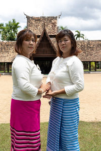 Portrait of sisters standing against temple