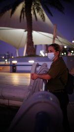 Face masked woman looking away on walking deck 