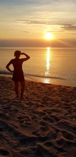 Rear view of woman on beach during sunset