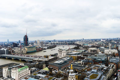 High angle view of city buildings against cloudy sky