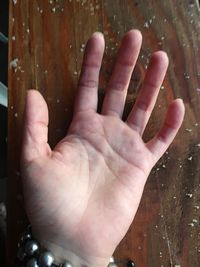 Close-up of person hand on wood