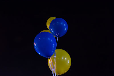 Close-up of blue balloons against black background