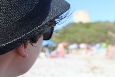 Close-up of woman wearing sunglasses on beach against sky