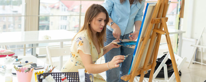 Young woman standing against indoors