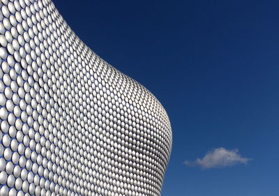 Low angle view of modern building against blue sky