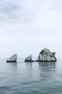 Rock formation in sea against sky