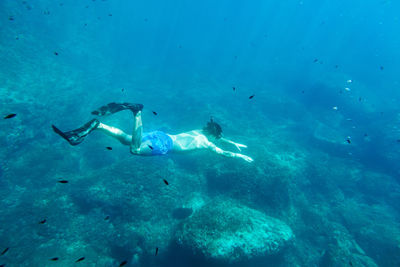 Shirtless young man scuba diving in sea