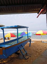 Chairs and parasols on beach against sky