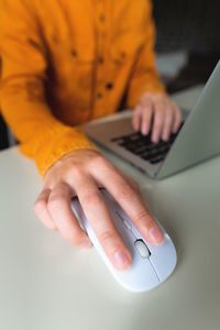 Close-up woman searching and clicking mouse using laptop, online shopping concept. blurred