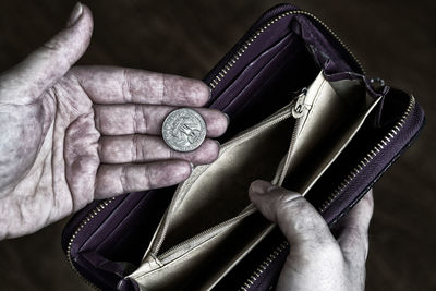 Cropped hands of woman holding purse with coin
