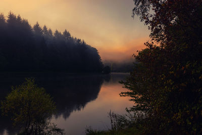 Scenic view of lake against sky at sunset