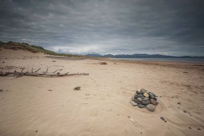 Scenic view of beach against cloudy sky