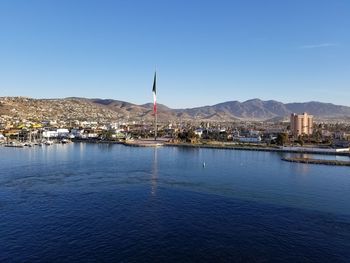 Scenic view of sea and buildings against clear blue sky