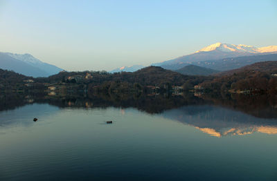 Scenic view of lake by mountains against clear sky