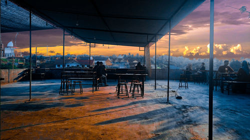 Silhouette people at restaurant against sky during sunset