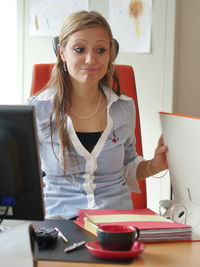 Portrait of young woman using laptop at table