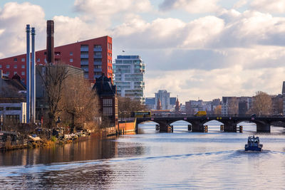 Bridge over river in city against sky