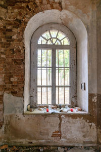 Photo with old arched windows in an abandoned church, iron grilles in front of the windows