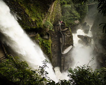 Scenic view of waterfall by mountain