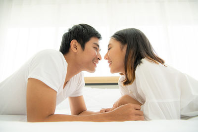 Side view of couple kissing on bed