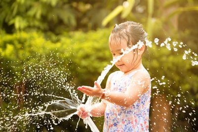 Close-up of girl paying with water