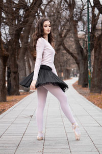 Side view of ballerina dancing on footpath