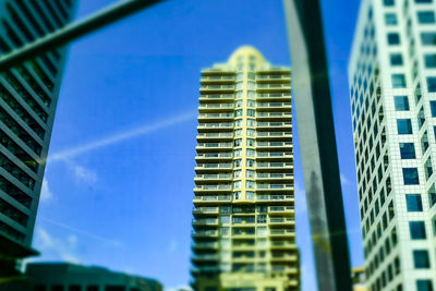 Low angle view of office building against blue sky