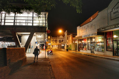 People walking on illuminated road at night