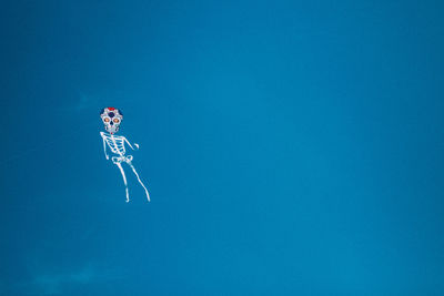 Low angle view of kite against clear blue sky