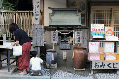 Rear view of people standing outside temple