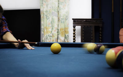 Cropped hand of woman playing pool