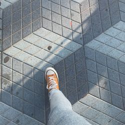 Low section of man standing on tiled floor