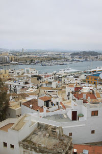 High angle view of cityscape by sea against sky