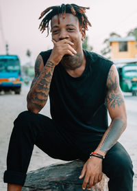 Young man looking at camera while sitting outdoors