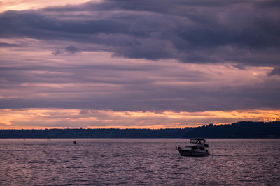 Boat sailing on sea against sky during sunset